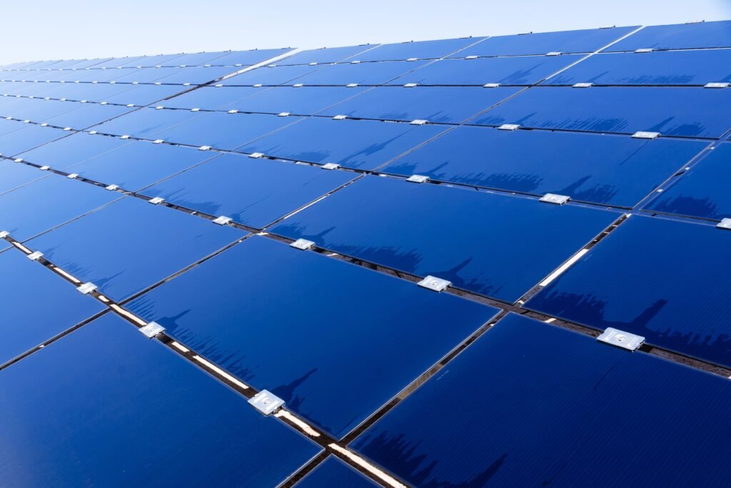 Wide view of solar panels under clear sky, showcasing renewable energy technology.